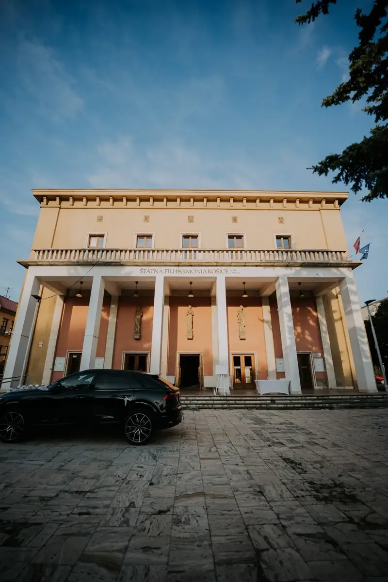 Dom umenia pri západe slnka s autom novomanželov